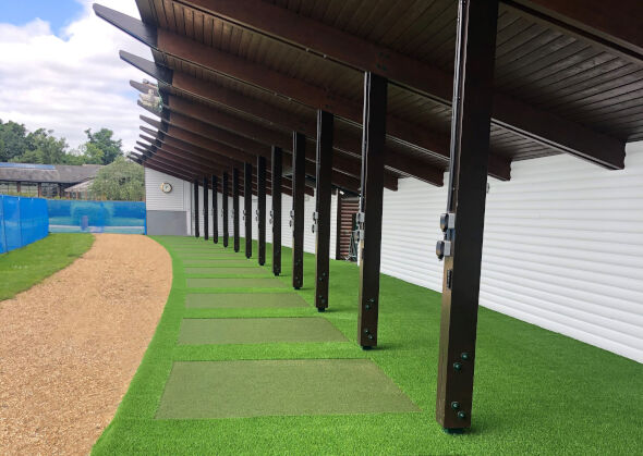 Kennewick Covered outdoor tee line with light green synthetic grass boxes inside a dark green synthetic grass strip